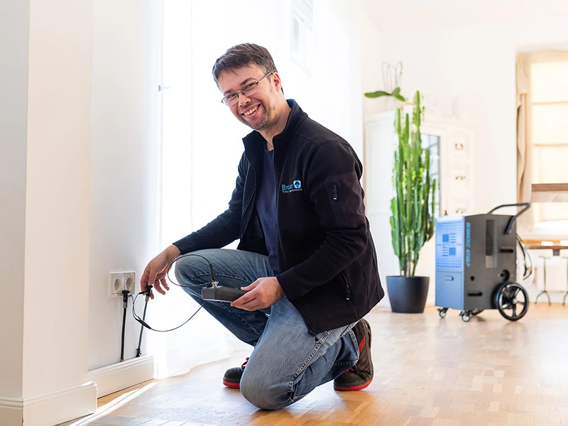 Techniker von Trocknungstechnik Brauer bei der Feuchtigkeitsmessung nach einem Wasserschaden